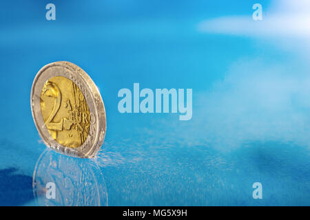 Münzen fallen ins Wasser. Stockfoto