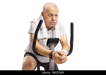 Erschöpft Senior auf dem Hometrainer auf weißem Hintergrund Stockfoto