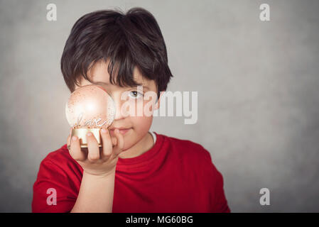 Liebe, Junge mit einer Glaskugel, die sein Auge Abdeckungen Stockfoto