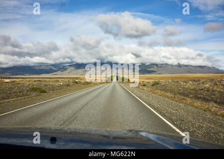 Fahrzeug schoss der Landstraße im argentinischen Patagonien. Die Berge im Hintergrund. Persönliche Perspektive. Fluchtpunkt. Stockfoto