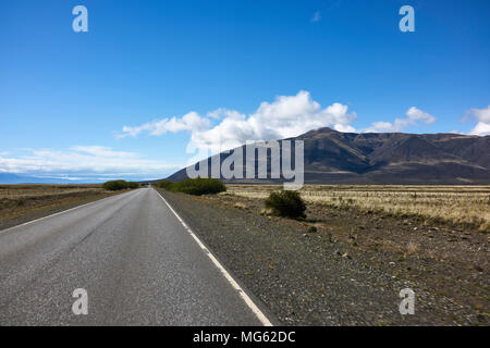 Autobahn in argentinischen Patagonien. Die Bergkette erstreckt sich im Hintergrund. Fluchtpunkt. Persönliche Perspektive; Stockfoto