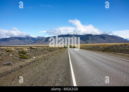 Autobahn in argentinischen Patagonien. Die Bergkette erstreckt sich im Hintergrund. Fluchtpunkt. Persönliche Perspektive; Stockfoto