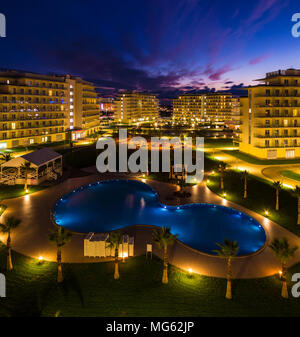 Adler, Sochi, Russland - Dezember 6, 2017: Nacht Blick auf das beleuchtete innere Gebiet der Hotelkomplex mit Wanderwegen, Palmen und Pool Stockfoto