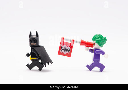 Mini Abbildung von Joker mit bang Pistole jagt Batman. Lego Minifiguren sind von der Lego Gruppe hergestellt. Stockfoto