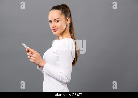 Freudige nette Frau ihr Smartphone Holding Stockfoto