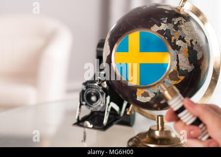 Reisen. Schwedische Flagge auf weltkugel unter der Lupe Stockfoto