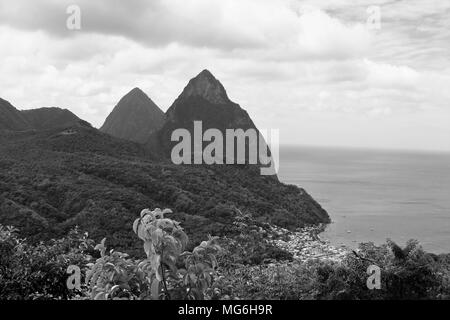 Ein Schwarz/Weiß-Screenshot des Pitons bergen überragt ein regen Wald und Dorf an der Küste auf der karibischen Insel St. Lucia. Stockfoto