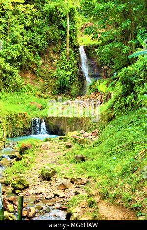 Einen üppigen grünen Hügel Gehäuse zwei kleinen Wasserfällen. Dies ist im Laufwerk liegt - durch Vulkan in St. Lucia, Karibik. Stockfoto