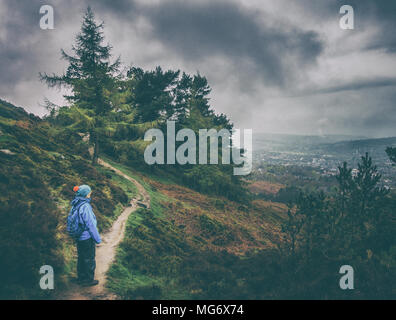 Ilkley Moor, West Yorkshire, UK. 27. April 2018. UK Wetter: Ilkley Moor, West Yorkshire, UK. 27. April 2018. Heavy Rain für viel des Tages gab atmosphärischen Bedingungen auf Ilkley Moor. Hier ein Weibchen Walker in voller imprägniert genießt die Moody Blick über Skipton. Quelle: Rebecca Cole/Alamy leben Nachrichten Stockfoto