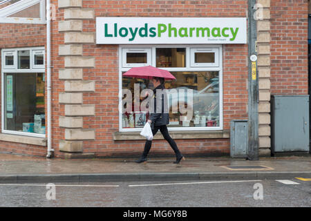 Stockton Heide Dorf. 27 Apr, 2018. UK Wetter: Wetter. Käufer Spaziergang durch die Cheshire Dorf Stockton Heide bei einem WOLKENBRUCH am Nachmittag des 27. April 2018 Credit: John Hopkins/Alamy leben Nachrichten Stockfoto