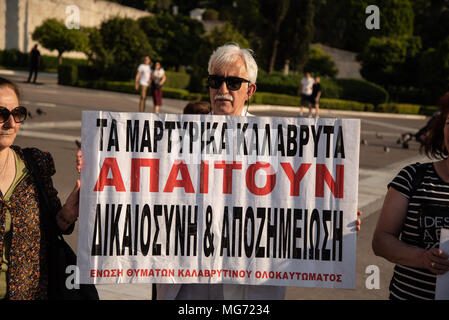 Athen, Griechenland. 27 Apr, 2018. Eine Demonstrantin hält ein Plakat gesehen, während der Demonstration. ersten Versammlung am Denkmal des unbekannten Soldaten, der März vorgenommen wurde, bis der Deutschen Botschaft für die Kompensation des Zweiten Weltkrieges aus Deutschland zu protestieren, als mehrere Massaker verewigt von deutschen Soldaten, die im Jahr 1943 begangen wurden. Credit: Vangelis Evangeliou/SOPA Images/ZUMA Draht/Alamy leben Nachrichten Stockfoto