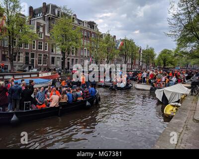 Amsterdam, Niederlande - 27. April 2018: King's Tag - sieht aus wie ein Stau auf dem Kanal, Personen, die eine gute Zeit genießen ihre Getränke auf dem Boot; King's Tag (früher Queen's Day) feiern Einheimische und Besucher einladen, bis zu tränken Amsterdam Open-Air-Spaß. In den Straßen, Kanäle, Parks und überall dazwischen, die Stadt ist voll mit Orange als Amsterdammers das größte Straßenfest des Jahres genießen.; Quelle: Bala Divakaruni/Alamy leben Nachrichten Stockfoto