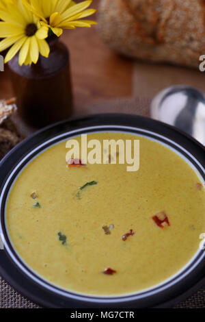 Leckere Cremesuppe Ort auf einer hölzernen Fach, Brot im Hintergrund. Raum für Text und kopieren Raum Stockfoto