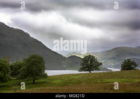 Ein Sonnenstrahl dringt in die düsteren Himmel über Ullswater, Lake District, Cumbria, England, Großbritannien Stockfoto