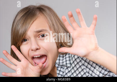 Emotionale Portrait von aufgeregten kleinen Mädchen. Lustig nett überrascht, Kind 10 Jahre alt mit der Mund vor Staunen offen. Schockiert Jugendlicher mit Händen in der Nähe der Uhr Stockfoto