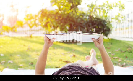 Asiatische Frau liest Buch outdoor. Stockfoto