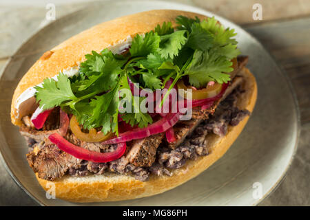 Hausgemachte mexikanischen Rindfleisch Torta Sandwich mit Koriander und Jalapenos Stockfoto