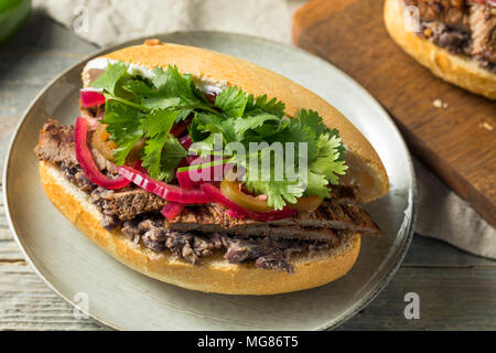 Hausgemachte mexikanischen Rindfleisch Torta Sandwich mit Koriander und Jalapenos Stockfoto