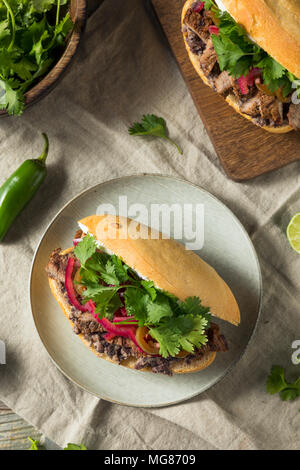 Hausgemachte mexikanischen Rindfleisch Torta Sandwich mit Koriander und Jalapenos Stockfoto