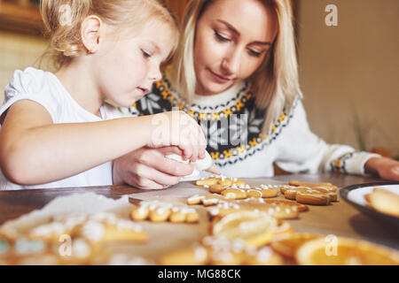 Süßwaren Arbeitsplatz mit Frauen Hände verzieren Weihnachtsplätzchen. Home Bäckerei, sonnigen Süß, Winterurlaub. Stockfoto