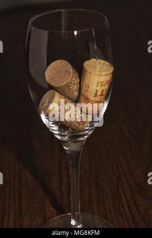 Wein Glas mit drei Korken innen auf einem Holztisch Stockfoto