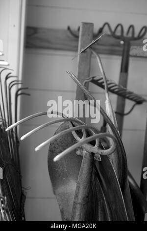 Im Garten arbeitende Werkzeuge sind in einem Schuppen gelagert. Stockfoto