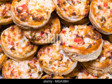 Köstliche portioniert Runde mini Pasteten aus knusprigem Blätterteig mit Frühlingszwiebeln Eier und Krabbenfleisch gefüllt und schmelzen Käse im Ofen gebacken und Stapel Stockfoto