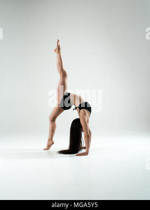Sportlich fit Woman in Black Sportswear im Studio tanzen, springen, ständigen Yoga und Fitness stellt. Gesund Leben und Sport Consept. Stockfoto
