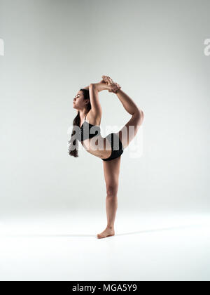 Sportlich fit Woman in Black Sportswear im Studio tanzen, springen, ständigen Yoga und Fitness stellt. Gesund Leben und Sport Consept. Stockfoto
