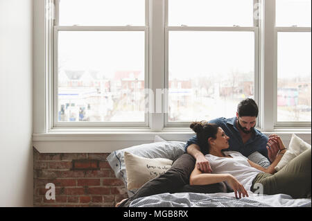 Der Mann und die Frau ruhig lag auf dem Bett, Hände halten und Kuscheln Stockfoto