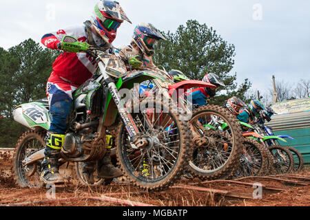 Reiter Ausfallschritt nach vorn zu Beginn der motocross Rennen auf dem Scrubndirt Motocross track am 3. Dezember 2016 in Monroe, GA. Stockfoto