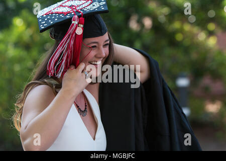 Ein lächelndes weibliche Absolventin bereitet auf ihrer Staffelung Gewand zu stecken, sie geht in Richtung Uga Abschlussfeier am 13. Mai 2016 in Athen, Ga. Stockfoto