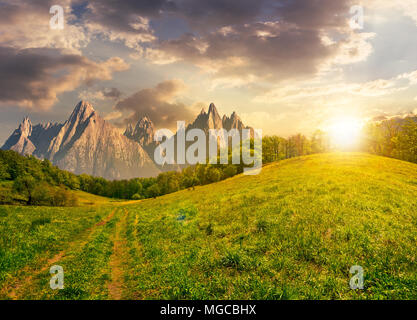 Zusammengesetzte Sommerlandschaft. Pfad durch den Wald auf grasbewachsenen Hügel in der hohen Tatra. schöne Sommerwetter mit blauen Himmel und einige Wolken am sunse Stockfoto