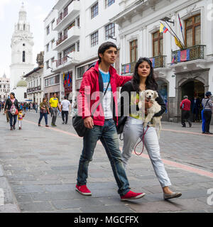 Junge heterosexuellen Paaren, genießen Sie die Spaziergänge durch die historischen Straßen der Stadt - Quito, Ecuador. Liebevoller Hund Mann und Frau mit Hund während Stadt laufen. Stockfoto