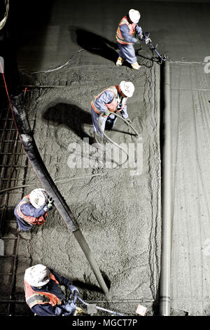 Die Arbeiter abziehen und schlichten Beton in der Montague Graben auf der BART ins Silicon Valley Berryessa Erweiterung Projekt in Milpitas, Kalifornien Stockfoto