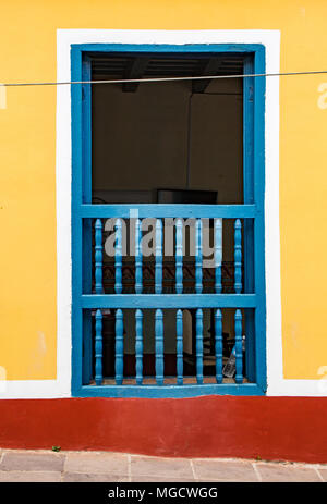 Trinidad, Kuba 26.November 2017 - Offene blaue Fensterläden, inneren Zimmer mit frisch lackiert Blau bewaldeten Gitter auf gelbe und rote Wal Stockfoto