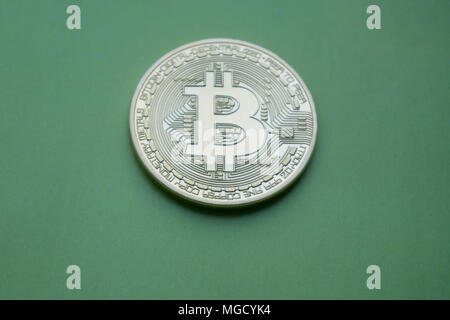 Golden Bitcoins (Digital virtuelles Geld) auf einem grünen Hintergrund. Stockfoto