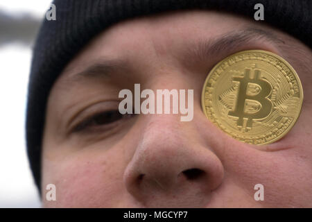 Ein ernster Mann mit bitcoin (Neues virtuelles Geld) Stockfoto