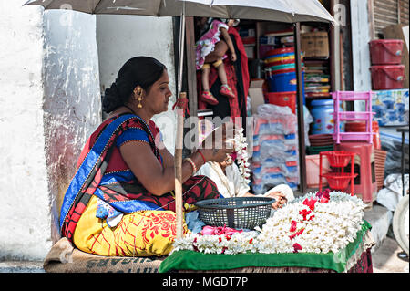 Mumbai, Indien - Dez, 30 2016: Die bunten frischen open air Gulmandi lokalen Markt. Frau in bunten sasee im Flower stall Macht weiss Girlande. Stockfoto