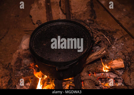 Kochen im Kessel am Brennen Lagerfeuer in der Nacht. Stockfoto