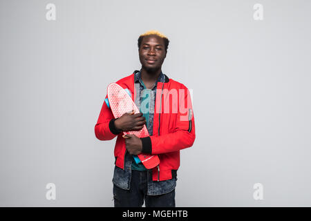 Stilvolle Junge afrikanische amerikanische Skater holding Longboard in der Hand auf hellen Hintergrund isoliert Stockfoto