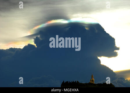 Cloud Schillern, Rainbow irisation gegen golden Big Buddha Statue auf Berg in Thailand. Stockfoto