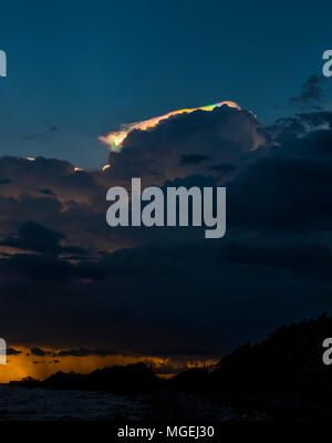 Cloud Schillern, Rainbow irisation über Golden Sea coast line. Stockfoto