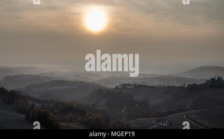 Eine Panorama-aufnahme in der Dämmerung an einem nebligen Tag in der Langhe, in Piemont, eine Gegend in der Nähe von Turin bekannt für seine Weine und Weinberge Stockfoto