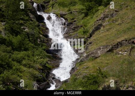 Eine einfache Stream mit Berg Wasser fließt durch den Rahmen inmitten von Wiesen und grünen Bäumen und Felsen, in Val Susa, in der Nähe von Turin im Piemont in Italien Stockfoto