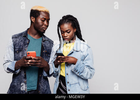 Afro American man Blick auf Frau Telefon weiß Sie chatten. Porträt eines Verdächtigen afro-amerikanische Paar mit Handy isoliert Stockfoto