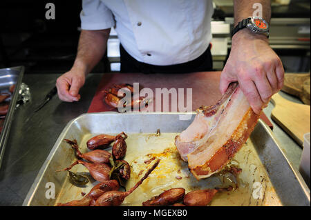 Essen Vorbereitung - karamellisierten Schweinefleisch mit Cherrueix schalotten von La Table du Marais Restaurant hacken, La Fresnais, Frankreich Stockfoto