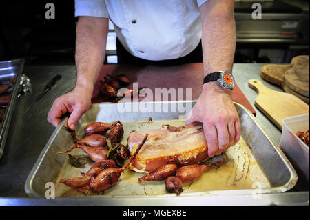 Essen Vorbereitung - karamellisierten Schweinefleisch mit Cherrueix schalotten von La Table du Marais Restaurant hacken, La Fresnais, Frankreich Stockfoto