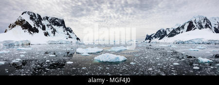 Panorama der schneebedeckten Berge und Wasser gefüllt mit Eis, Lemaire Kanal, Antarktis Stockfoto