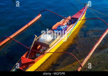 Ein buntes 2-Mann fischer Outrigger, bangka, leuchtet am späten Nachmittag Sonne in Puerto Princesa, Palawan, Philippinen. Stockfoto